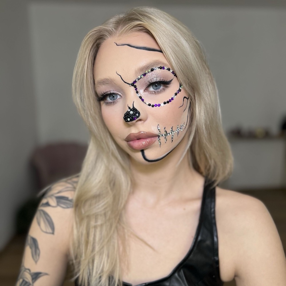 Mój makijaż halloweenowy z kryształkami: połowa twarzy w stylu czaszki, oko obrysowane czarno-fioletowymi dżetami